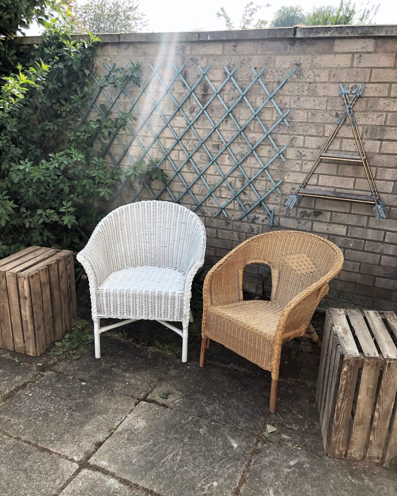 a garden patio featuring vintage wicker chairs and rustic apple crates 